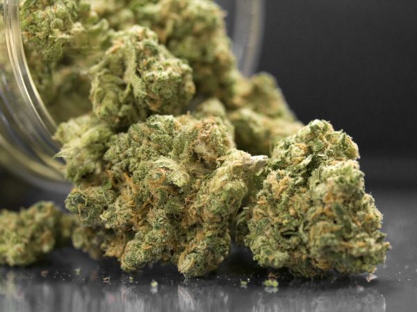 Close Up Of Cannabis Flowers In Jar And Table